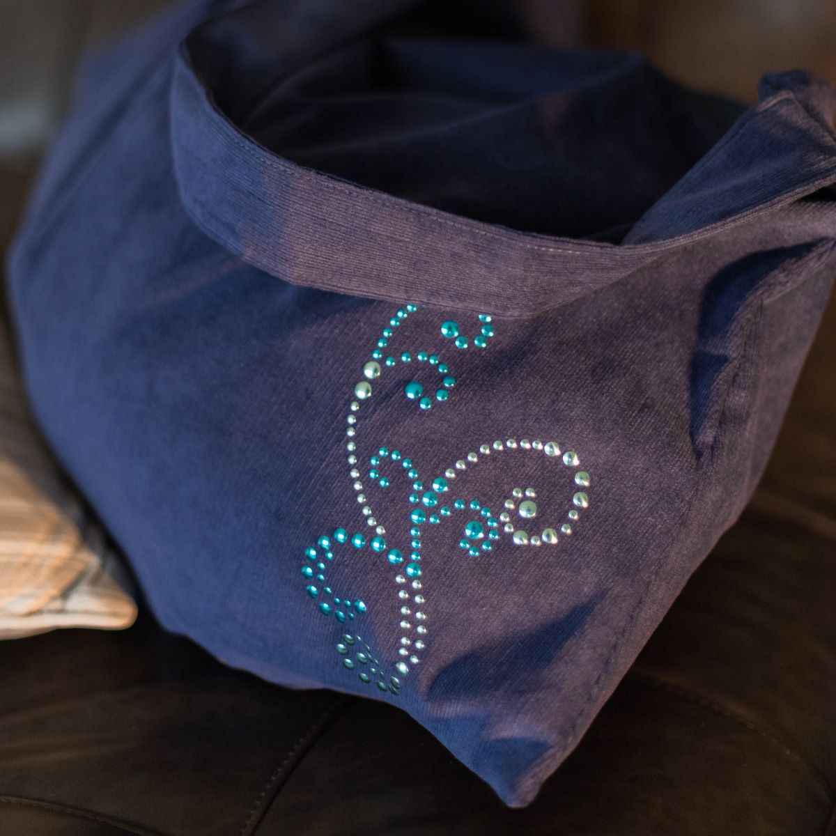 Sac en velours bleu customisé avec strass thermocollants formant un motif décoratif