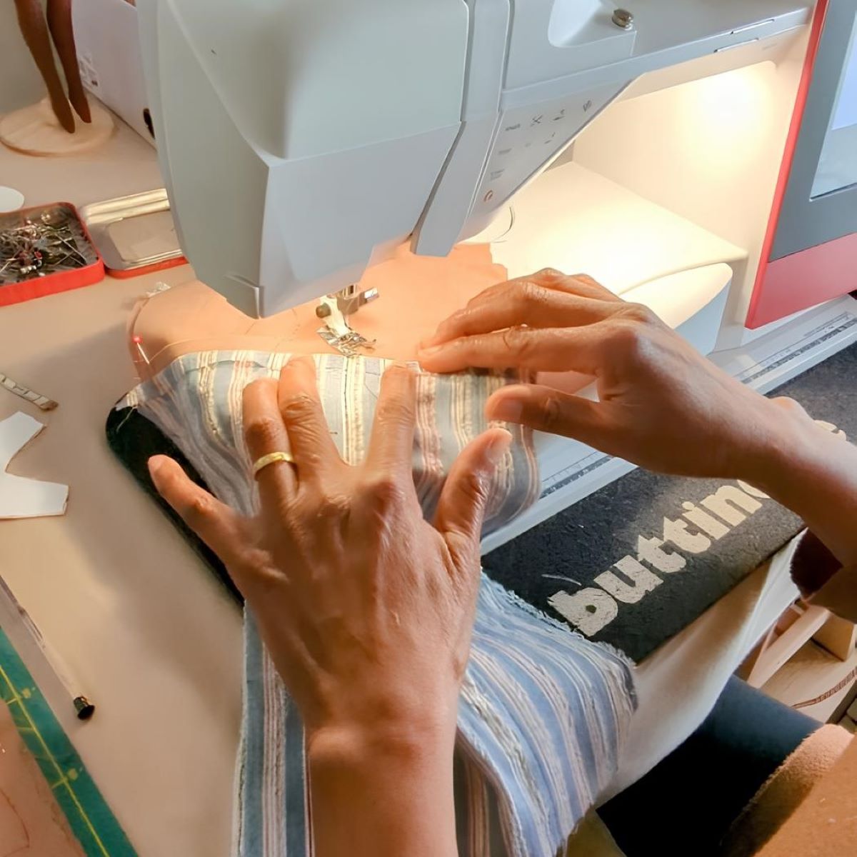 Des mains entrain de coudre à la machine