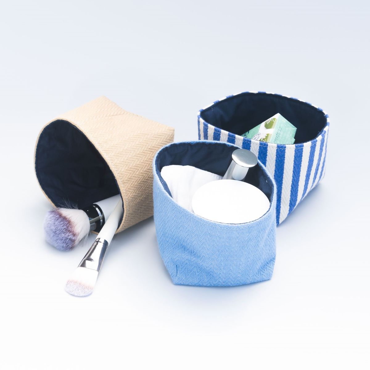 Trois panières du vanity bleu contenant des affaires de maquillage