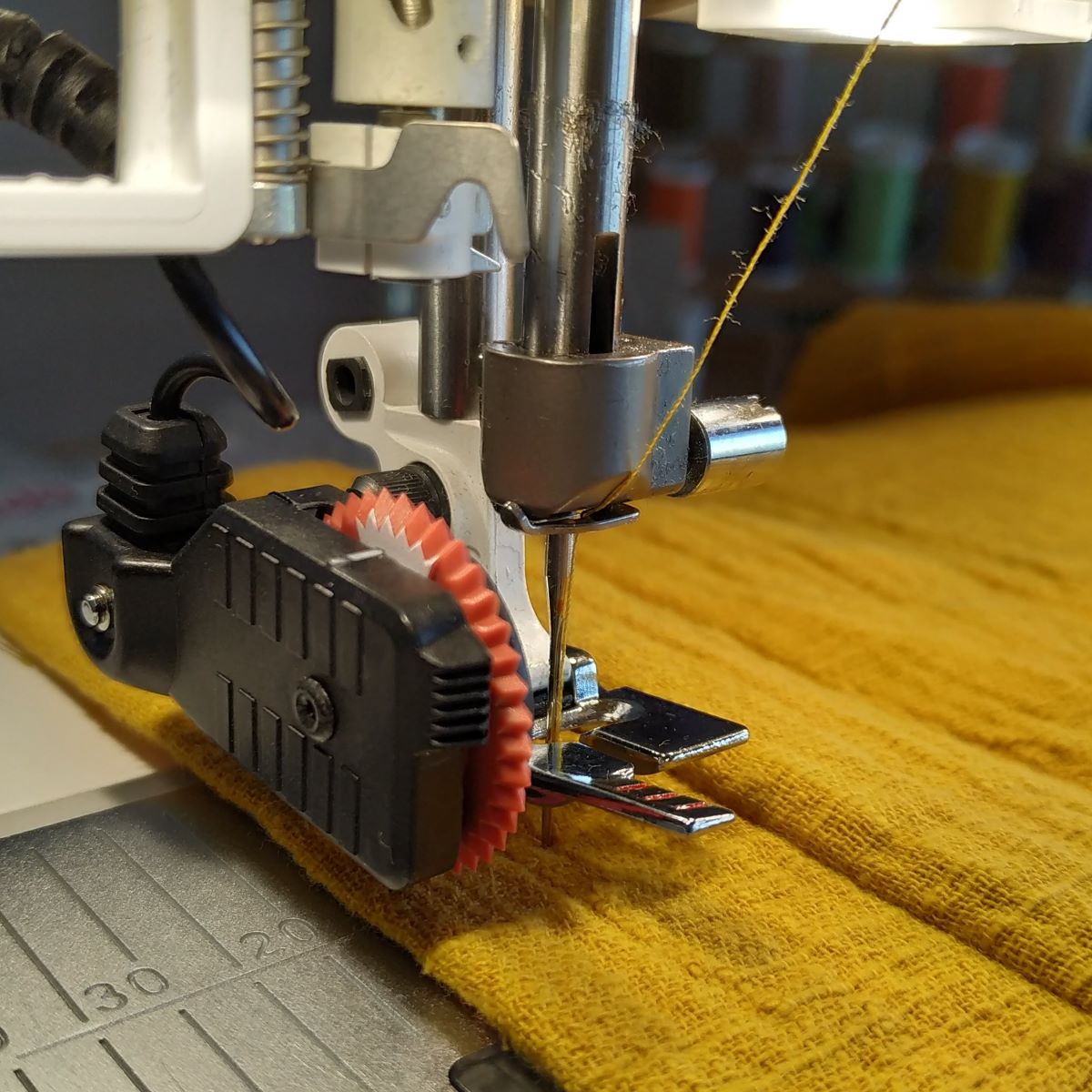 Couture d'une boutonnière avec le pied Senseur sur un tissu jaune moutarde