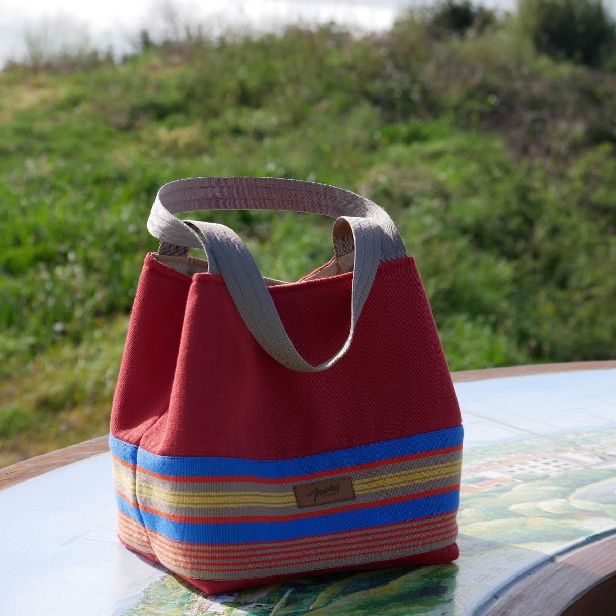 Mini cabas en toile basque terracotta et rayures posé sur une table d'orientation - création Les doigts de Lily